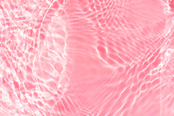 Pink water bubbles on the surface ripples. Defocus blurred transparent pink colored clear calm water surface texture with splash and bubbles. Water waves with shining pattern texture background