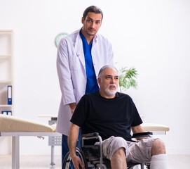 Old injured man visiting young male doctor traumatologist