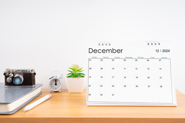 Desktop Calendar for December 2024 year and vintage camera with diary for Planner to plan timetable.