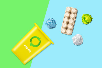 Yellow trash can. With a recycling icon for paper. On a blue-green background. Garbage sorting. Ecology. Garbage