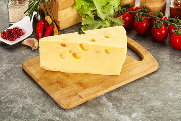 Swiss Maasdam cheese triangle over board