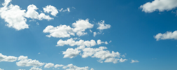 Sun shining through the puffy clouds. Sky view. Beautiful sunny sky. Background with clouds on blue...