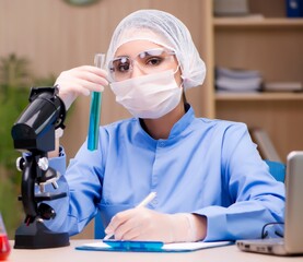 Lab chemist working with microscope and tubes