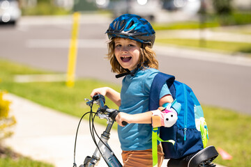 Naklejka premium Sporty kid riding bike on a park. Child in safety helmet riding bicycle. Kid learns to ride a bike. Kids on bicycle. Happy child in helmet cycling outdoor. Sports leisure with kids.