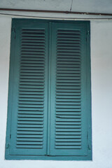 front view of wooden lattice window in classic old building wall.