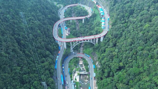 Payakumbuh, Indonesia - June 24, 2024: Stunning aerial drone views of Kelok 9, a scenic serpentine road in West Sumatra, showcasing its dramatic curves and lush surrounding landscapes. Perfect for tra