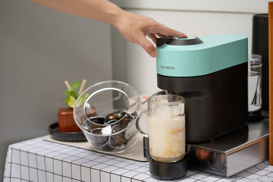 Pathum Thani, THAILAND August 03, 2024-Man using capsule coffee machine with espresso cup. Nespresso is worldwide leader company with coffe machines and capsules.