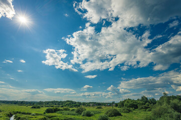 Obraz premium A clear blue sky with a few clouds and a sun shining brightly