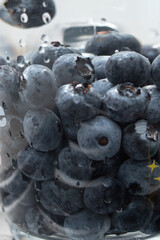 American blueberries in a transparent glass with water. Washing berries. Healthy eating. Vitamins.