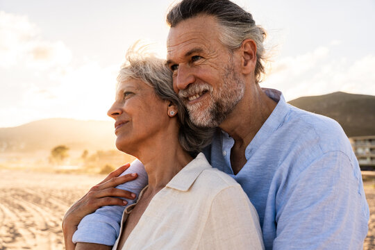 Beautiful happy senior couple dating at the seaside during summertime - Mature married couple in love bonding outdoors at the beach, concepts about elderly lifestyle, relationship and quality of life - Powered by Adobe