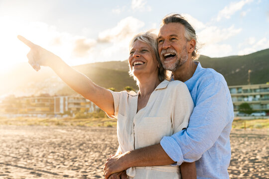 Beautiful happy senior couple dating at the seaside during summertime - Mature married couple in love bonding outdoors at the beach, concepts about elderly lifestyle, relationship and quality of life - Powered by Adobe