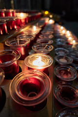 Rows of lit and unlit votive candles in a Christian church, inside the Salamanca Cathedral, in Castilla y Leon, Spain