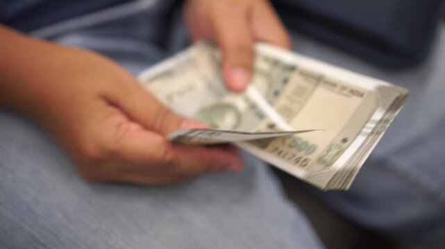 Indian Rupee banknotes on hands, Indian rupee (INR) is official currency in India and subdivided. Businesswomen's hands counting money for paying shopping goods services