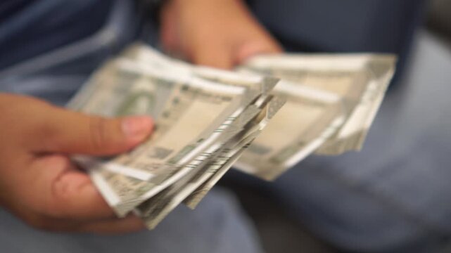 Indian Rupee banknotes on hands, Indian rupee (INR) is official currency in India and subdivided. Businesswomen's hands counting money for paying shopping goods services