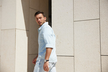 Surprised man turning around a corner, looking back with a startled expression