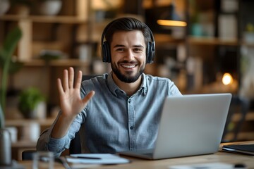 Obraz premium businessman wears headset smilingly talks to a video call on a laptop with waving hand. businessman connecting virtually with clients. virtual meetings, customer support