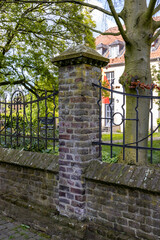 European brick fence covered with moss and vegetation
