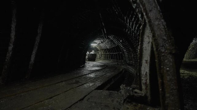 mine workers pushing a coal wagon in a mine.