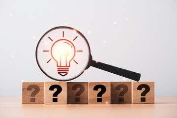 Glowing light bulb inside magnifier glass on question mark for focus and concentrate of creative...