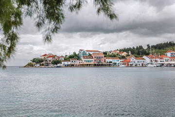 Fototapeta premium Fiskardo village on the Ionian Island of Kefalonia Greece, summer vacation destination, cloudy sky and beautiful landscape scenery