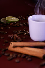 Fragrant coffee with smoke in a white cup. Cinnamon and cardamom background