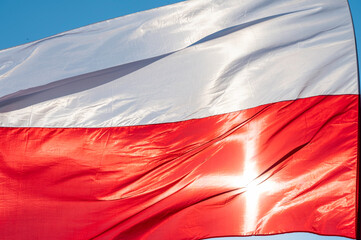 Powiewająca flaga biało czerwona. Flaga Polski na tle niebieskiego nieba © smoku7979