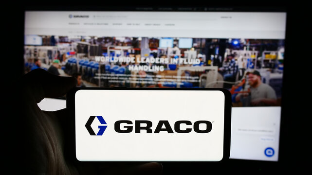 Stuttgart, Germany - 07-24-2024: Person holding cellphone with logo of US fluid-handling equipment company Graco Inc. in front of business webpage. Focus on phone display.