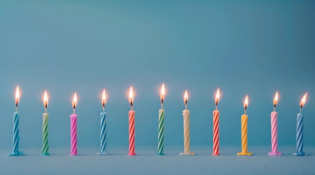 colorful holiday candles are burning, standing in a row on a blue background.