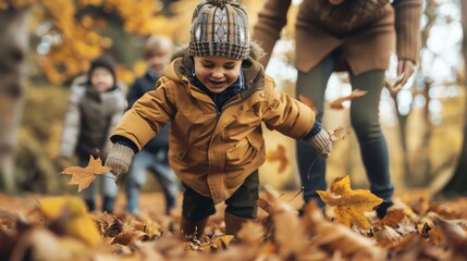 A little boy in a yellow jacket and a knitted hat is playing in a pile of autumn leaves, as his family watches.