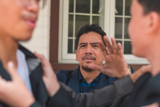 A father tries to break up a fight between his two sons, telling them to stop. Emotions run high as the conflict unfolds.