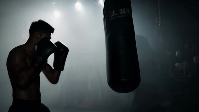 Professional african american boxer man punching bag in dynamic boxing action in ring of a sporting arena silhouette. Sportsman workout. Fitness box exercise. Active fit sport training indoor.