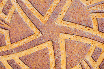 Rusty metal manhole cover. Grunge steel pattern texture. Heavy iron backdrop. Industrial star shape design background. Orange rust iron background. Round steel symbol.