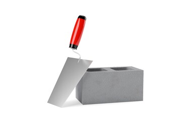 Single gray concrete or cement brick stone with metal trowel leaning against over white background, construction, building trade or masonry industry concept