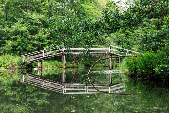 Idyllische Holzbr&uuml;cke &uuml;ber den Puhlstrom im Spreewald, Spiegelung der Br&uuml;cke in der Spree, Land Brandenburg, Deutschland
