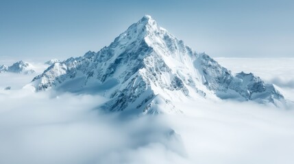 Majestic snow-covered mountain peak rising above soft, white clouds, creating a serene and tranquil atmosphere in nature.