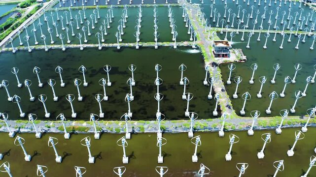Drone aerial shot of large white vertical axis wind turbine power plant wide angle and close-up, green energy