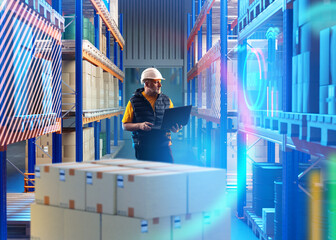 Man in innovation warehouse. Storage manager holding laptop. Storekeeper stands among racks boxes. Guy at delivery service warehouse. Man contractor for warehouse company. Virtual screens near racks