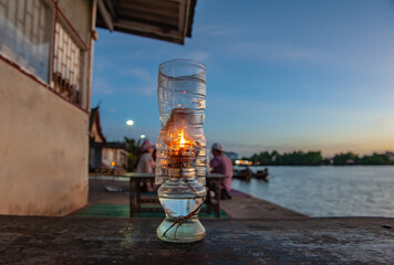 Tea table and oil lamps by the river in the evening