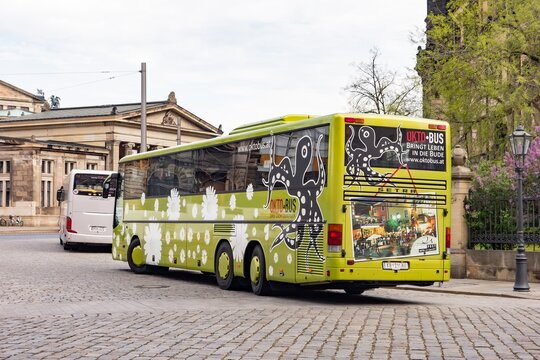 Setra luxury bus of OktoBus transportation company parked in Dresden, Germany with Altstadtische Hauptwache in background