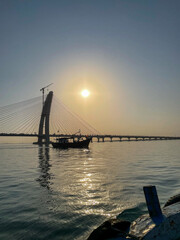 A beautiful sunset view of a boat sailing in a river .