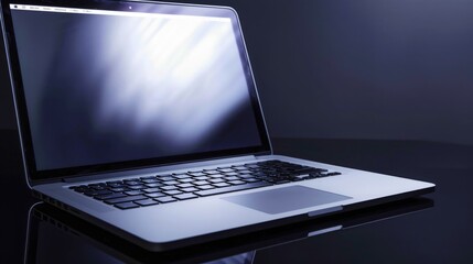 Laptop on dark polished surface with soft spotlight