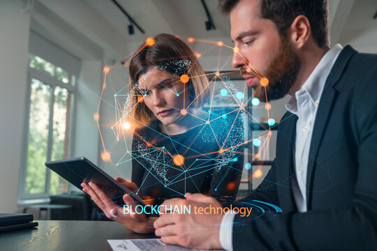 Business professionals discussing blockchain technology in an office setting.