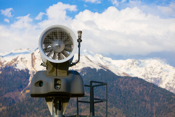 Close-up of snow cannon fan in mountains at springtime. Fan type snow machine. Turned off snow gun...