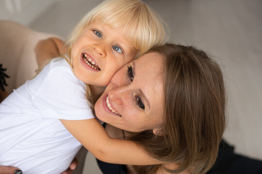 Portrait of mother and her little son at home, child boy with strabismus eyes, squinting eyes, cross-eyed. Happy smiling faces