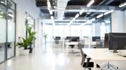 Blurred view of a modern office space with desks and computers.