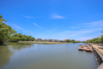 Fototapeta premium May 17 2024 poled boat, parked at deck in Yanagawa with green willow leaves