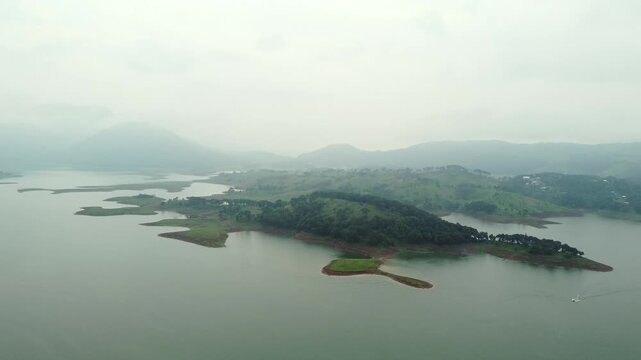 Aerial view of umiam lake serene blue water with misty mountains aerial image is taken at umiam lake shillong meghalaya india. it is showing the breathtaking beauty of nature.