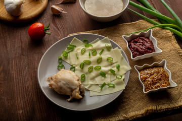 Dagestan khinkal dough, meat, meat broth, with mustard and adjika on the table next to a spoon on a napkin