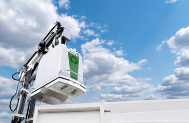 Garbage truck lifts street bin for recyclable waste