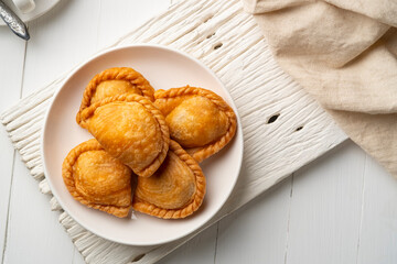 curry puff in white plate,fried curry dumpling (with meat or vegetable snuffing).Top view